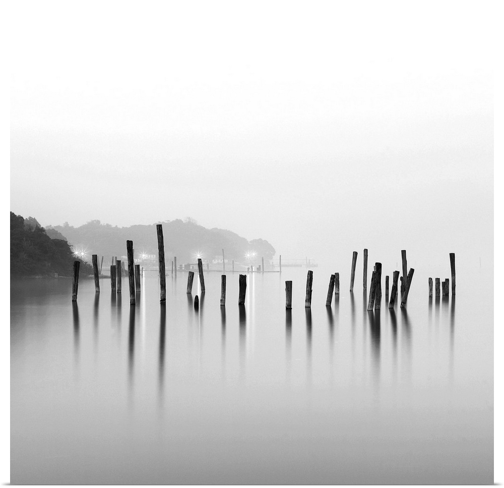 Black and white square image of an old pier in mist.
