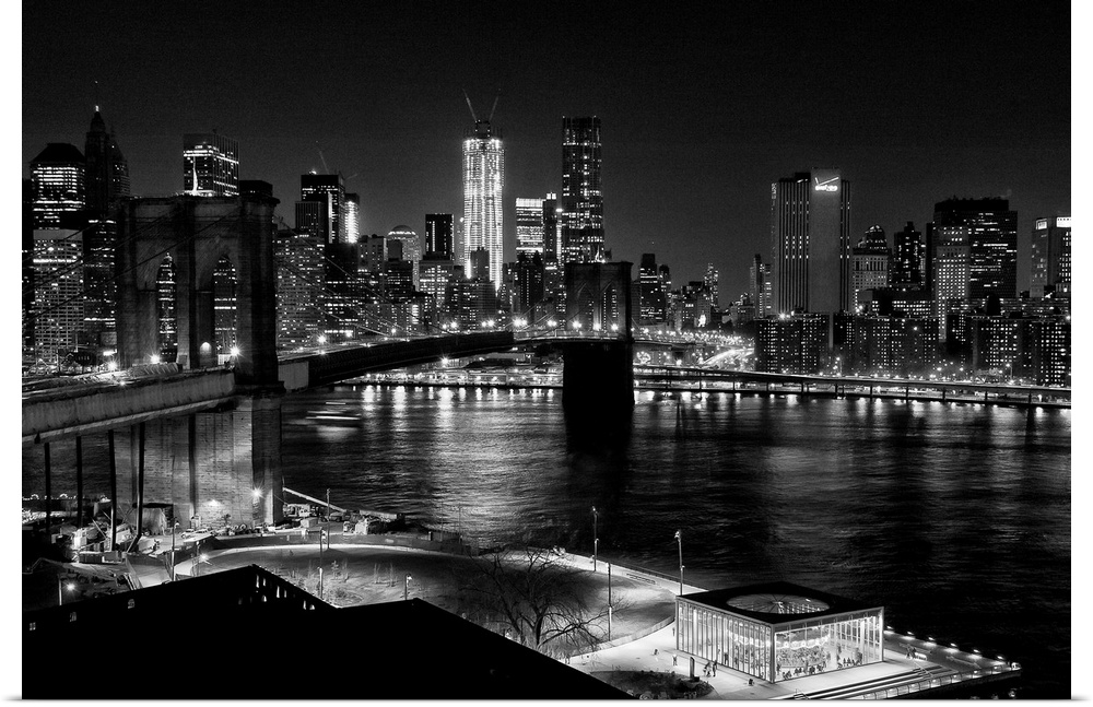 Black and white photograph of a city skyline at night. With abridge spanning over bay.