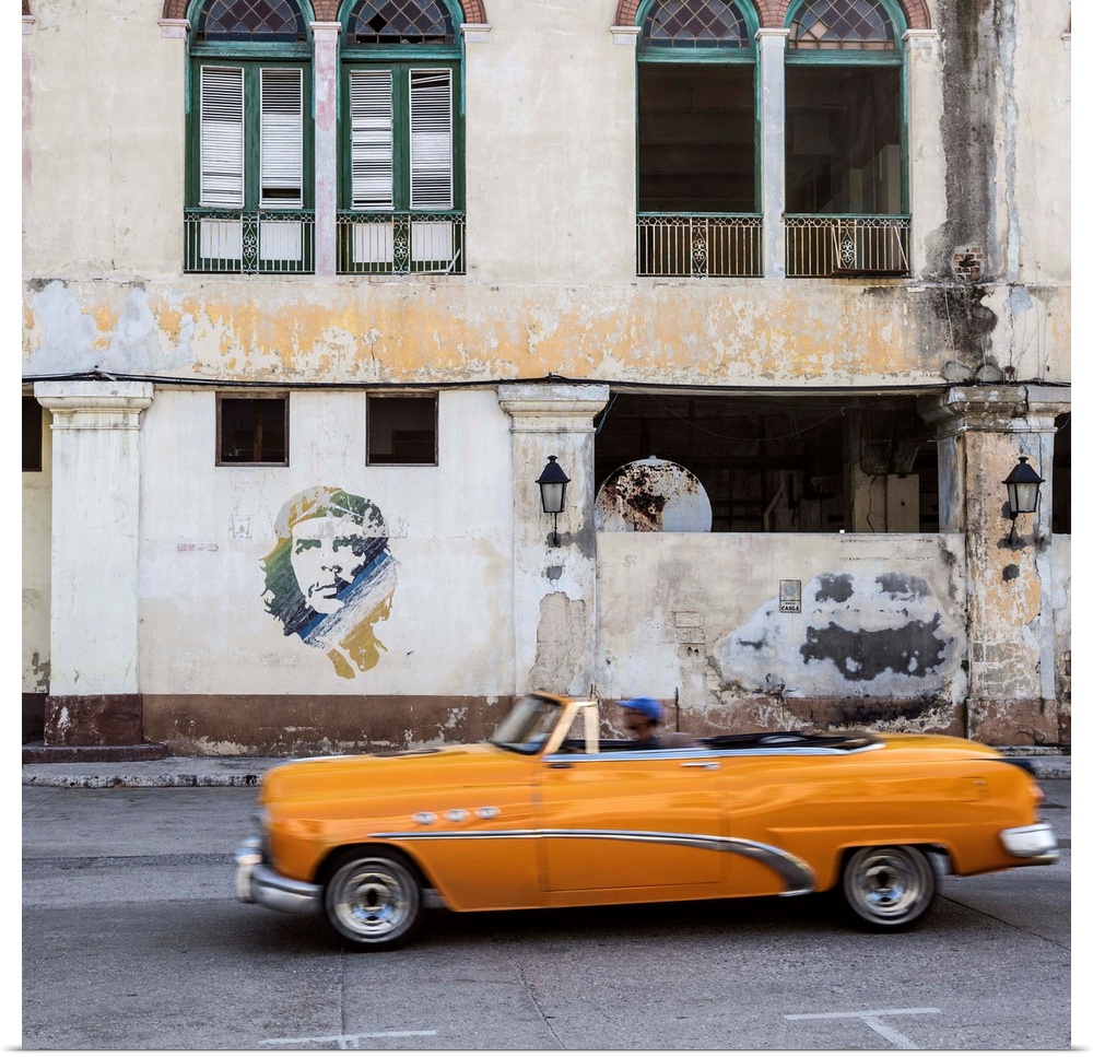 50's Classic American car passing a mural of Che Guevara, Habana Vieja, Havana, Cuba.