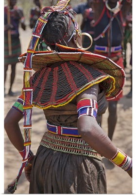 A Pokot woman in traditional attire dances to celebrate an Atelo ceremony