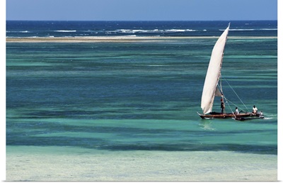 A traditional outrigger canoe sails close to the shore at Diani Beach