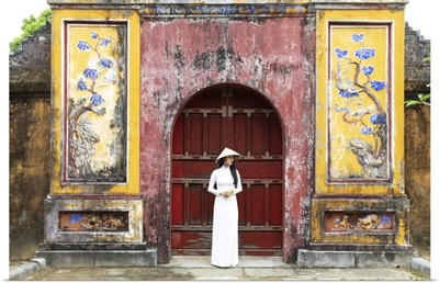 A Vietnamese Girl Stands In Front Of Historical Gate In Hue Imperial Citadel, Vietnam