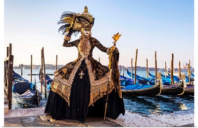 A Woman In A Costume Poses In Front Of Gondolas During The Venice Carnival, Italy