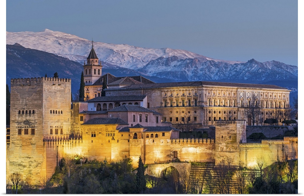 View at dusk of Alhambra palace with the snowy Sierra Nevada in the background, Granada, Andalusia, Spain.