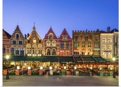 Belgium, Bruges. Medieval guild houses and restaurants on Markt square at dusk