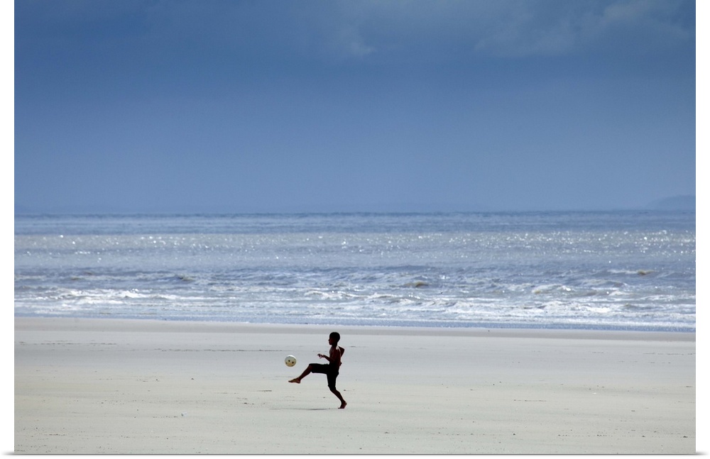 South America, Brazil, Maranhao, Sao Luis, Sao Marcos beach, boy playing football on the beach
