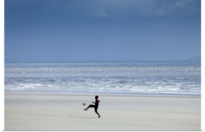 Brazil, Maranhao, Sao Luis, Sao Marcos beach, boy playing football on the beach