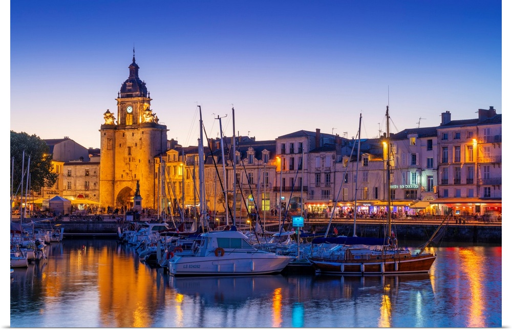 France, Poitou Charentes, La Rochelle, Old Harbour, Porte de La Grosse Horloge at dusk.