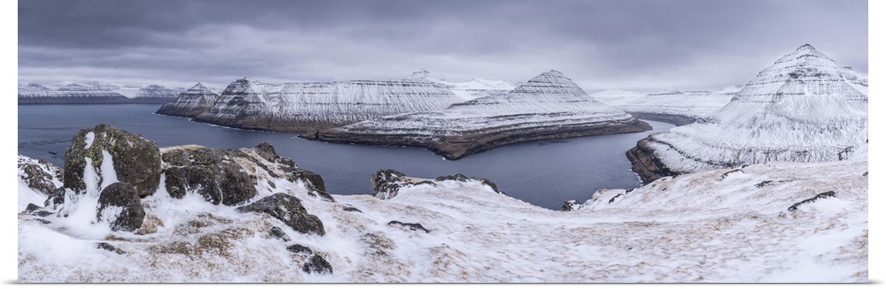 Snow covered mountain scenery above Funningsfjordur on the island of Eysturoy, Faroe Islands, Denmark, Europe. Winter (Apr...