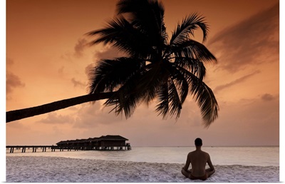 Maldives, Meemu Atoll, Medhufushi Island, Man meditating on the beach
