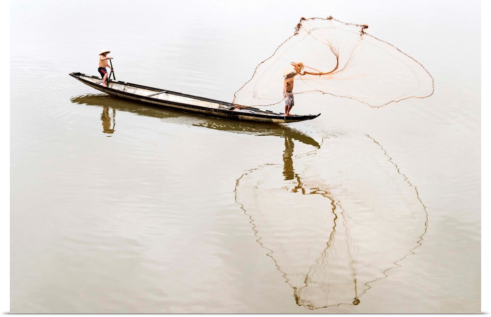 Net casting fishermen on the Perfume River, Hue, Vietnam.
