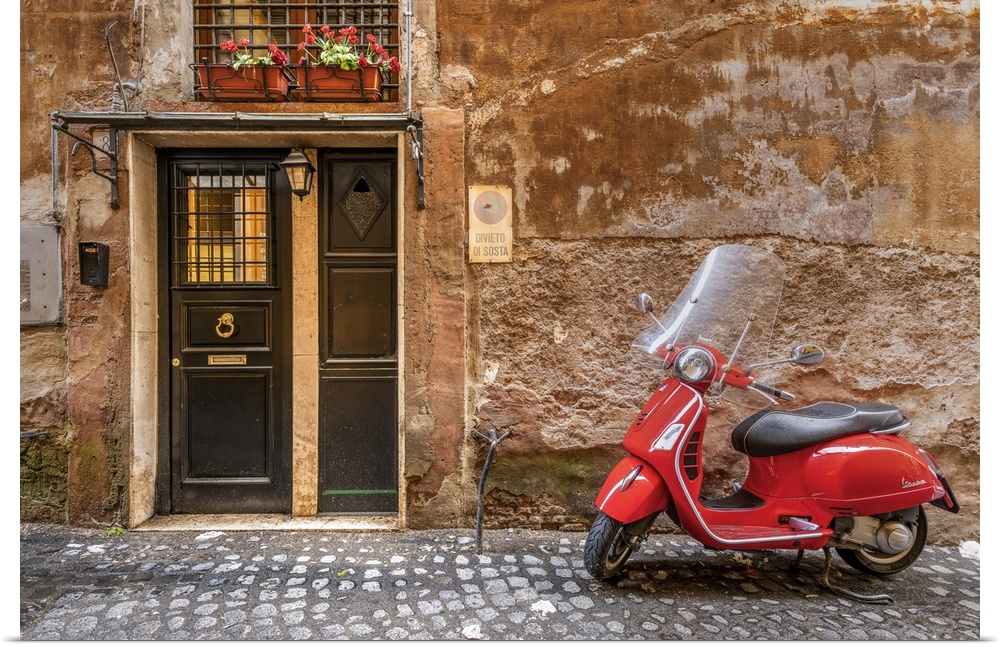Parked red Vespa scooter in a cobbled street of Rome, Lazio, Italy