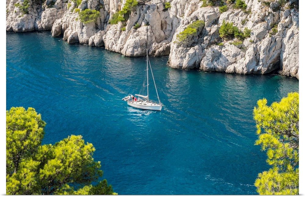 Sailboat passing through emerald blue water of Calanque de Port-Pin, Cassis, Bouches-du-Rhone, Provence-Alpes-Cote d'Azur,...