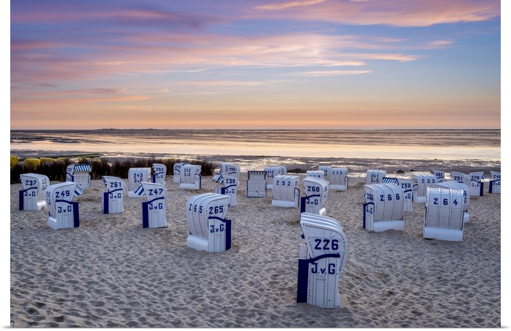 Duhnen, Cuxhaven, Lower Saxony, Germany. Strandkorb beach chairs and the Wadden Sea at sunset.