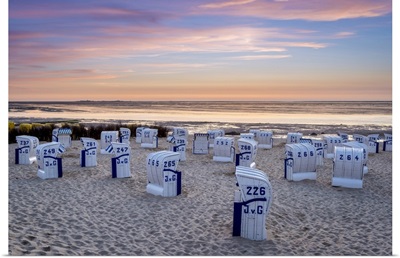 Strandkorb beach chairs and the Wadden Sea at sunset