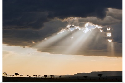 Sun breaks through rain clouds in the Masai Mara National Reserve
