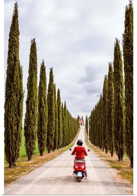 Tourist riding an italian vespa motorcycle in the countryside. Tuscany, Italy