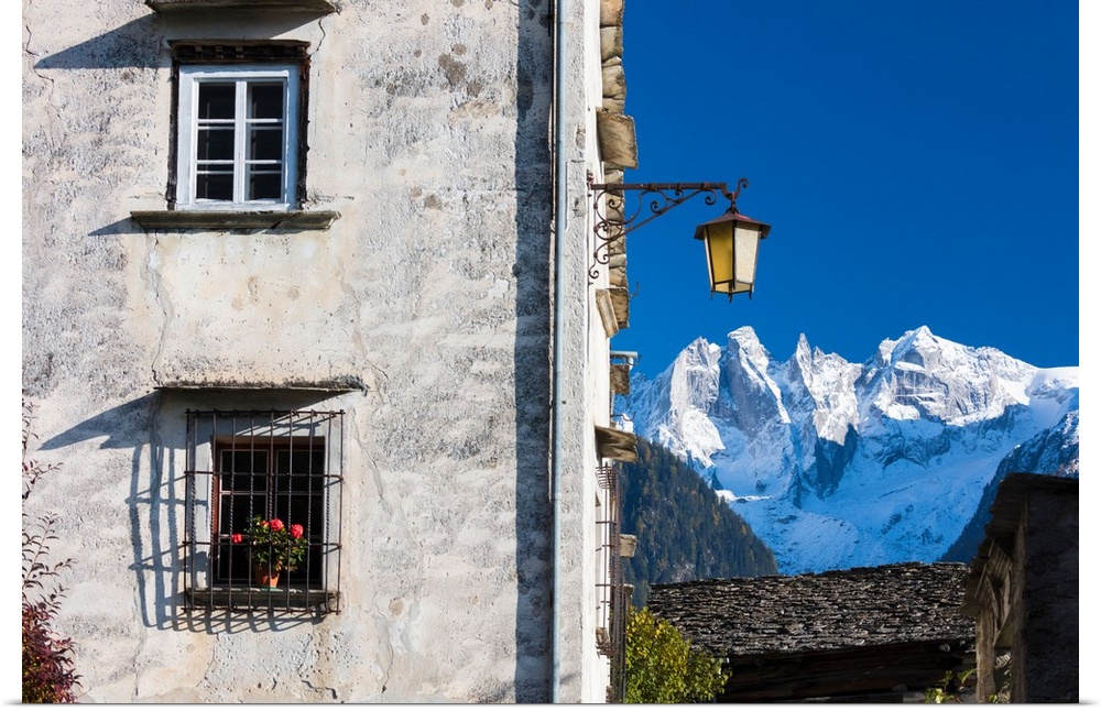 Typical alpine house and street lantern frame the snowy peaks Soglio Bregaglia Valley canton of Graubunden Switzerland Europe