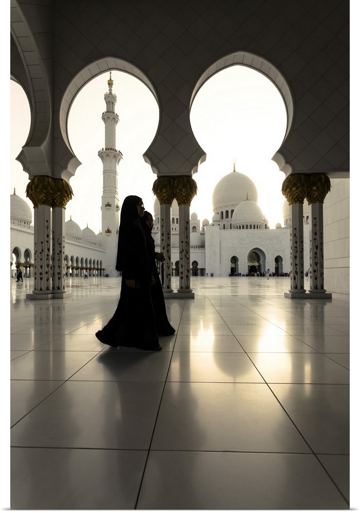 United Arab Emirates, Abu Dhabi. Arabic women walking inside Sheikh Zayed Grand Mosque at sunset