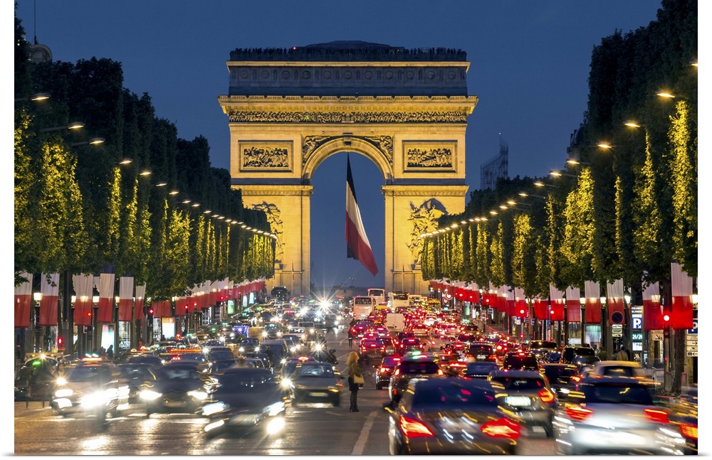 View down the Champs Elysees to the Arc de Triomphe, illuminated at dusk, Paris, France.