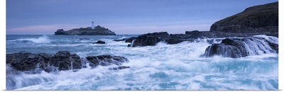Waves crash around the rocks near Godrevy Lighthouse, Cornwall, England