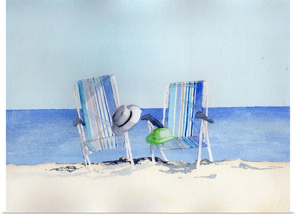 Two striped beach chairs with hats on a sandy beach.