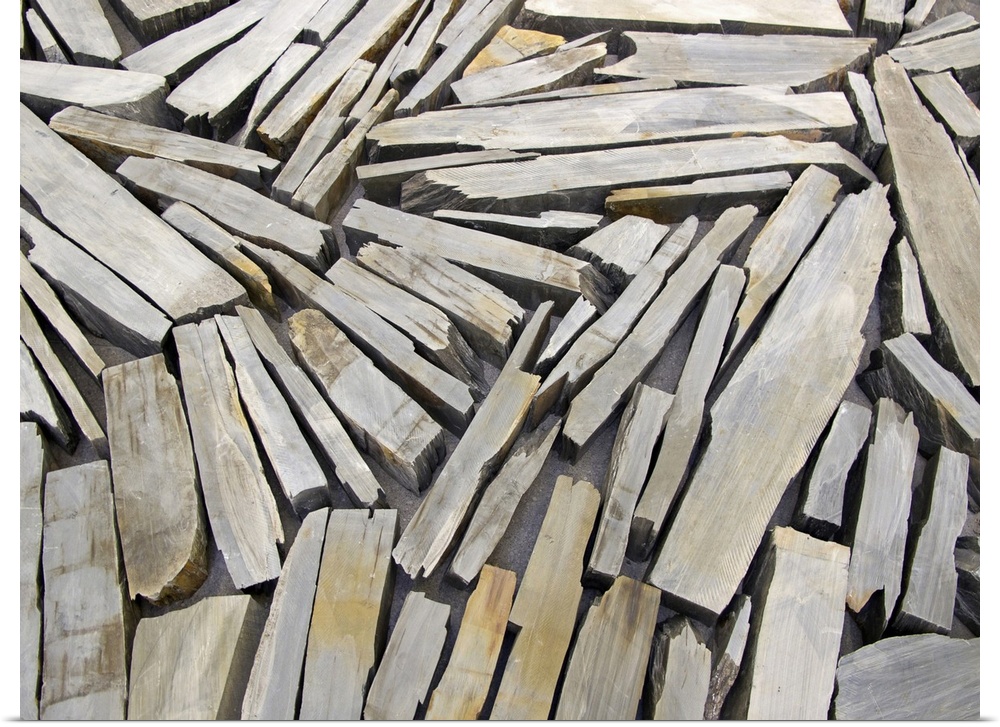 Photograph of wood pieces varying in length and width, and oriented in all directions, arranged in a collage-like manner.
