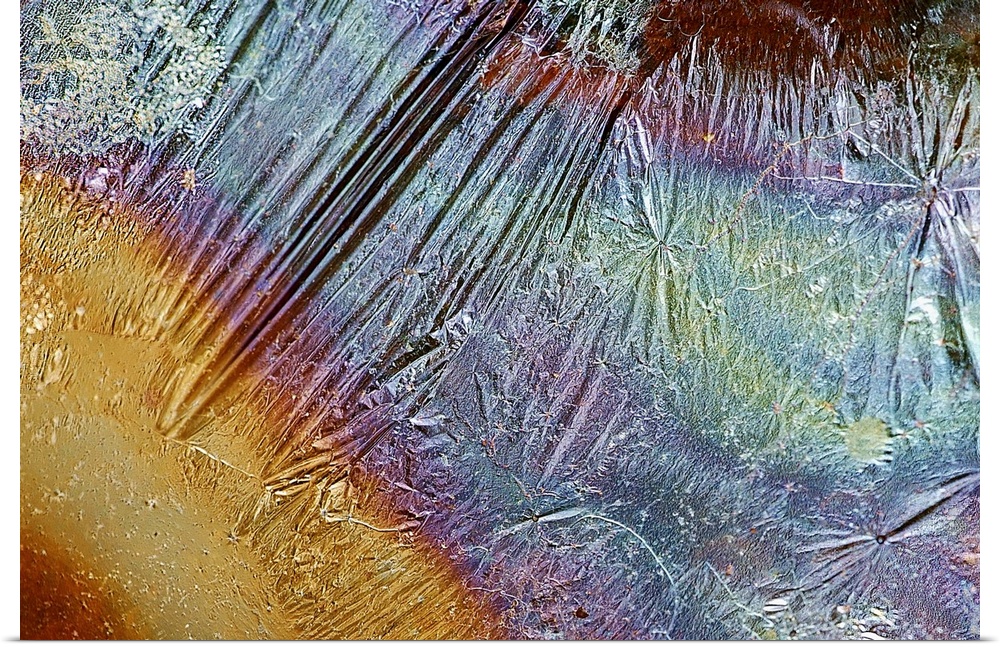 Photograph of grease on top of a piece of rippled foil creating multicolored bands of color.