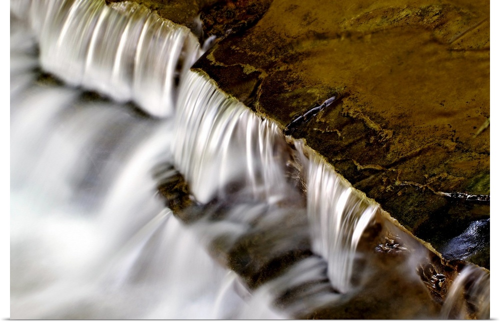 Large photo print of water rushing downward off of rock formations.