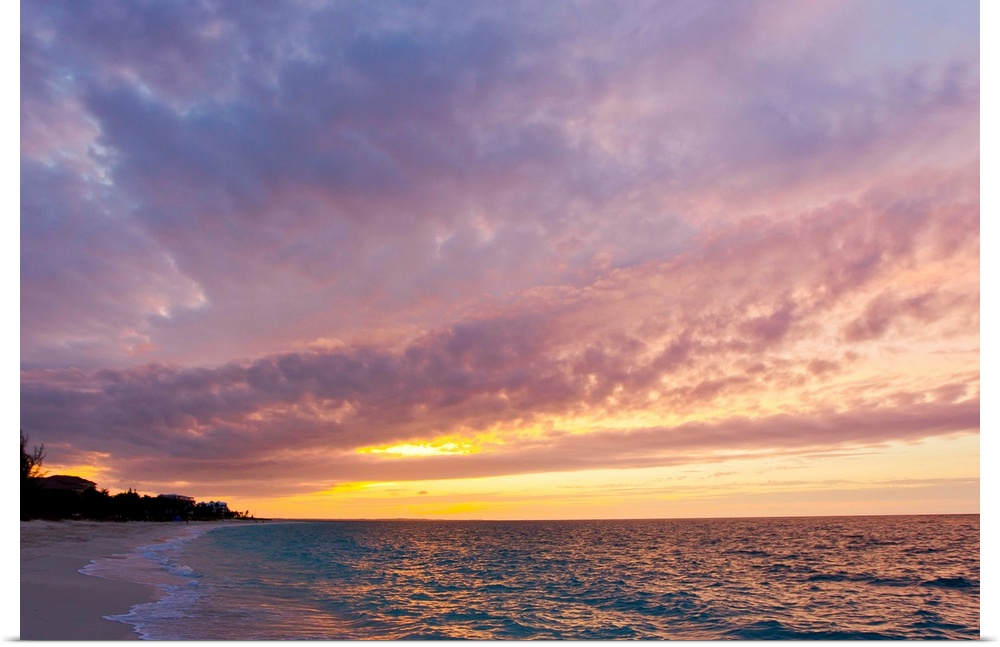 A purple and pink sky at sunset over Grace Bay and the beach.