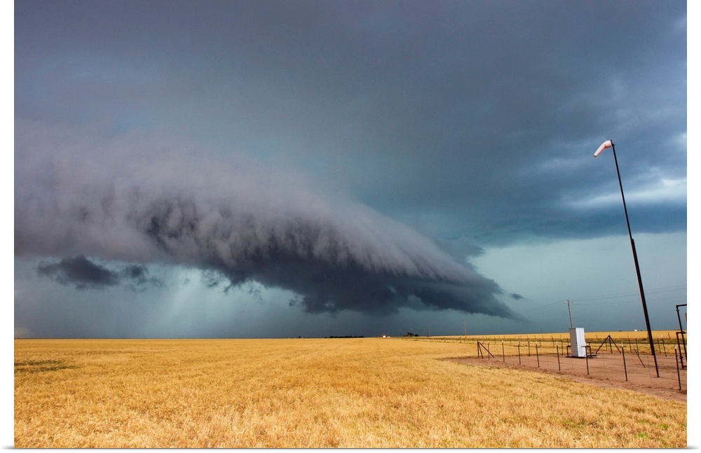 A shelf cloud from a thunderstorm provides water to crops.