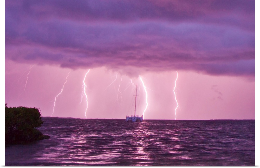 Lightning bolts striking the ocean, and almost hitting a sailboat.