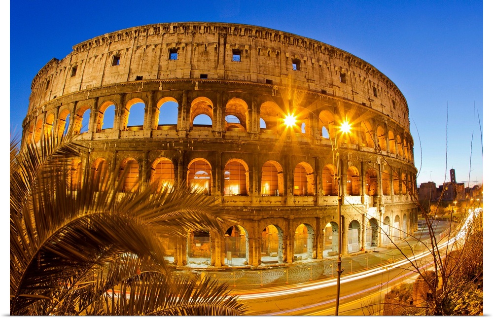 The ancient Roman Colosseum casts an illuminated golden light at dusk.