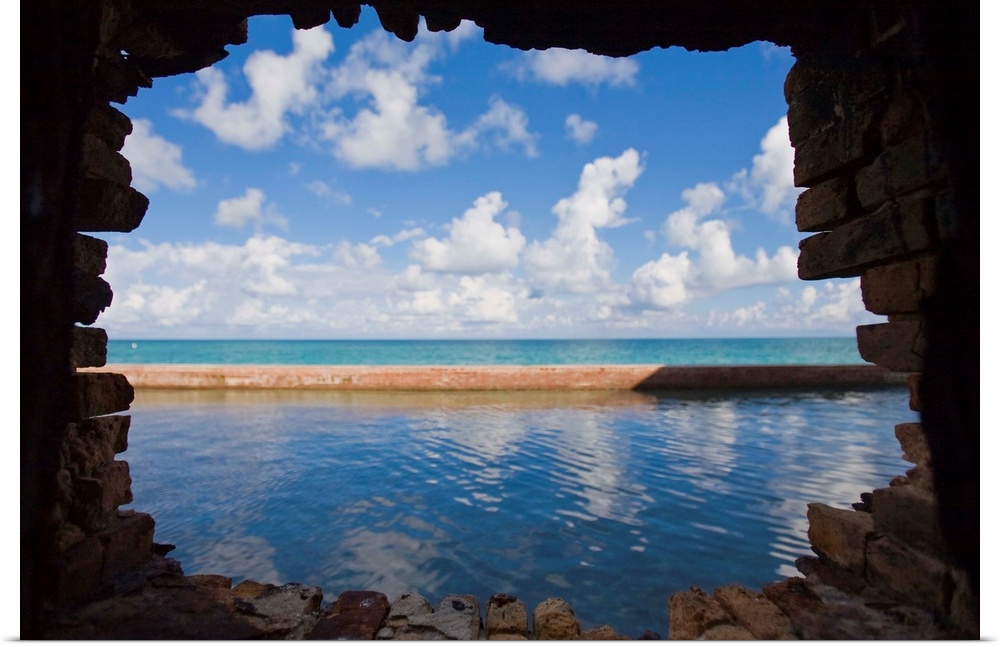 Water and clouds seen through a hole in a brick wall at Fort Jefferson.