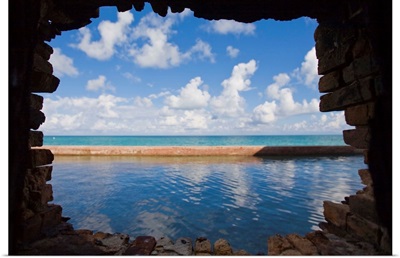 Water and clouds seen through a hole in a brick wall at Fort Jefferson