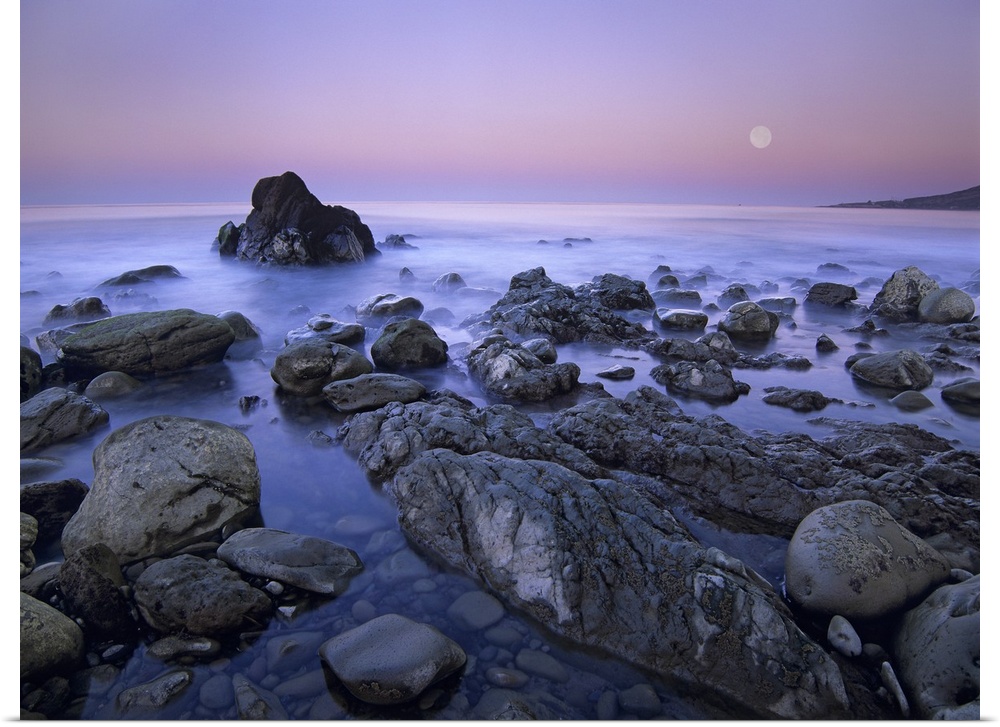 Full moon over boulders at El Pescador State Beach, Malibu, California