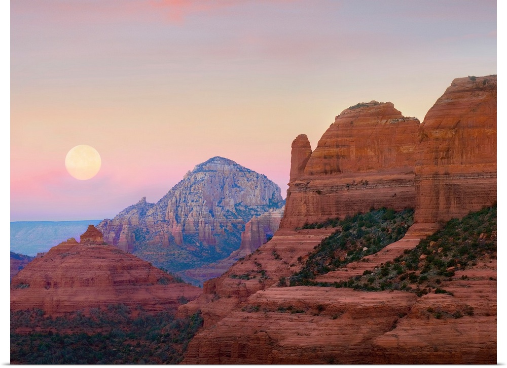 Large, horizontal photograph of the moon setting in the early morning sky, over the large rock formations near Shelby Hill...