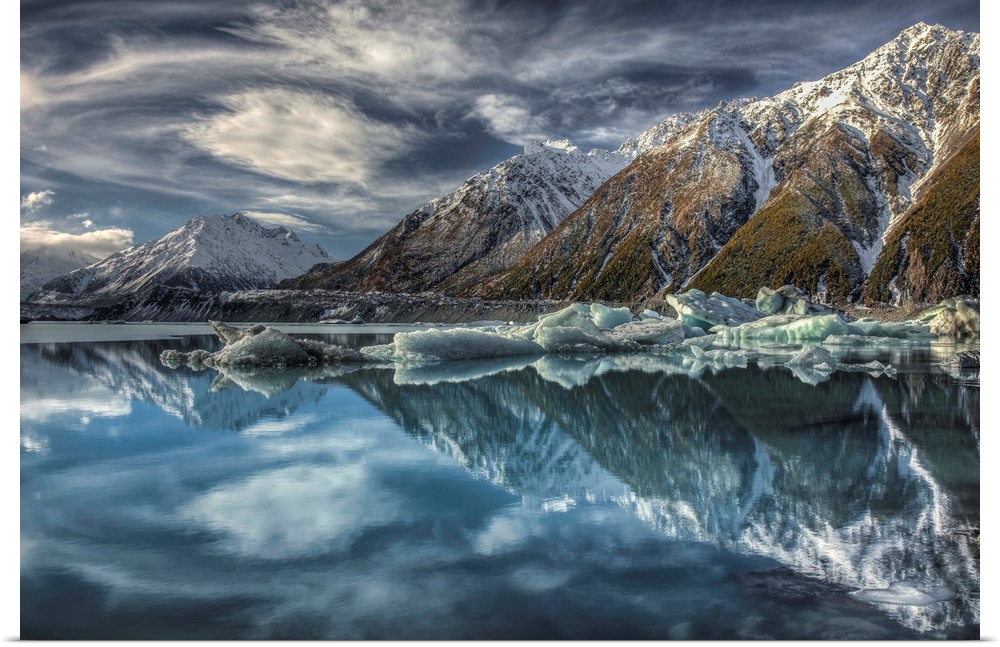 Mirror image, reflection of clouds, peaks and icebergs in Tasman Glacier Lake, Mount Cook National Park, New Zealand
