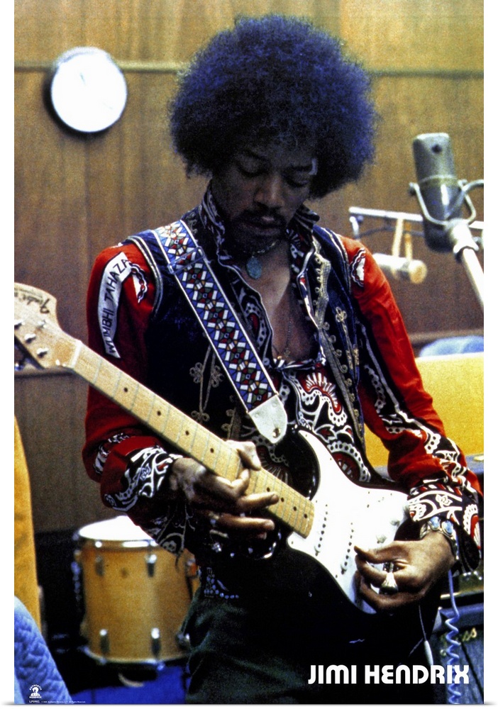 Vintage color photograph of the musician Jimi Hendrix strumming an electric guitar and wearing a brightly decorated and em...