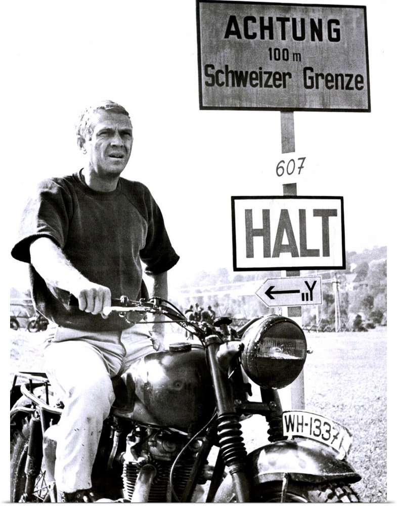 Vertical movie advertisement for the 1963 film, The Great Escape.  A man sits on a vintage motorcycle next to a German roa...