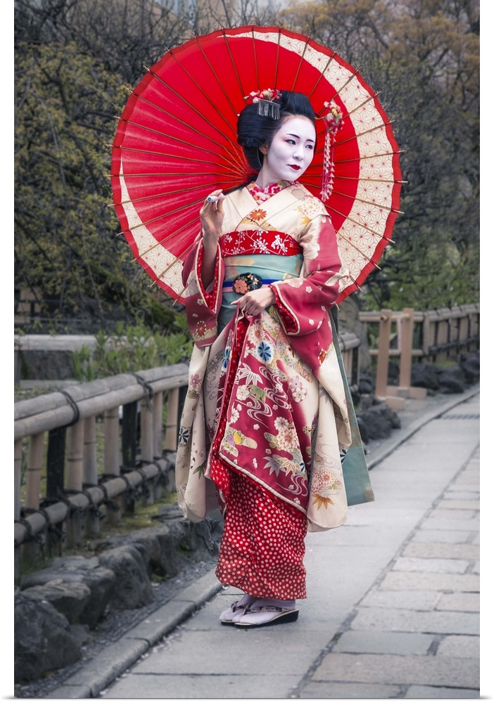 A photograph of a woman in traditional Japanese geisha attire.