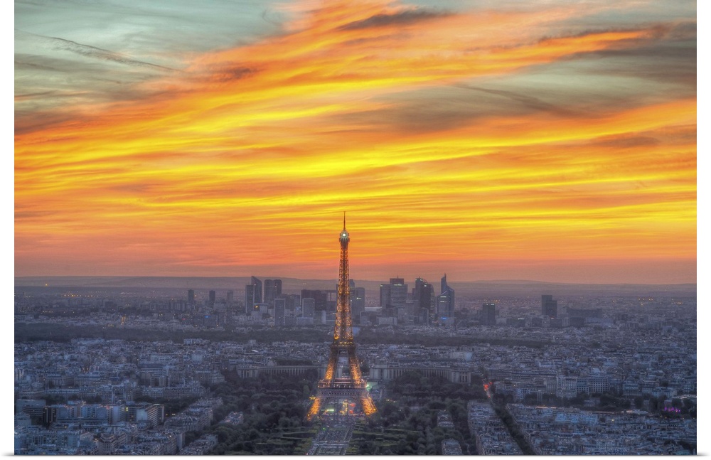 Vibrant photograph of the Eiffel tower standing tall in the center of Paris during sunset.