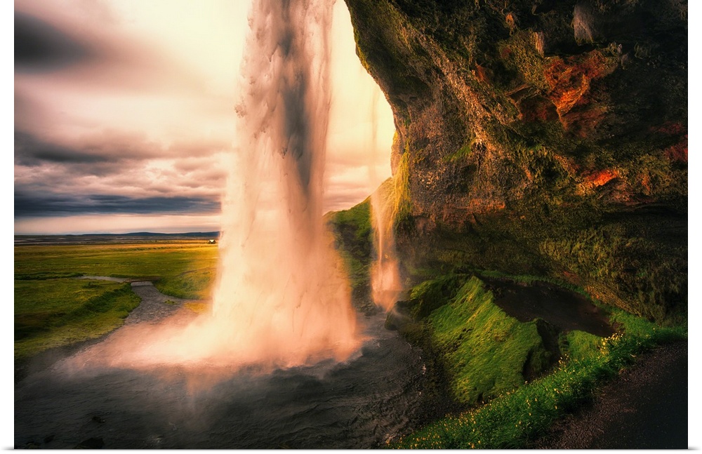View of the Seljalandsfoss Waterfall Behind from a Cave at Sunset, Iceland