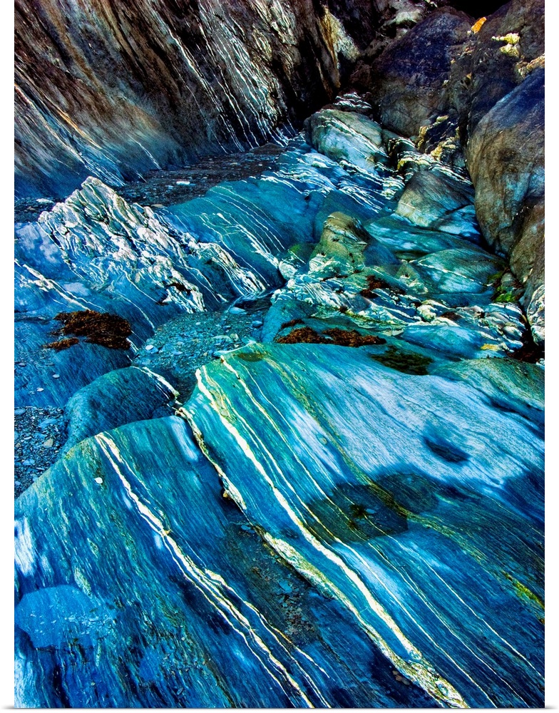 Fine art photo of a turquoise stream flowing over a rocky riverbed.