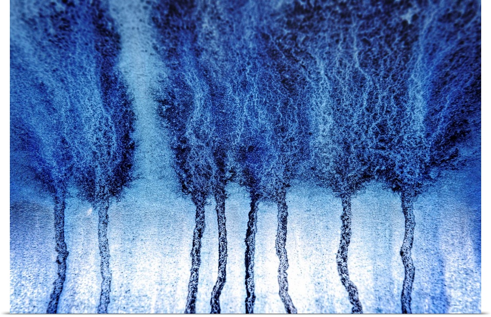 Abstract artistic photograph of blue paint dripping down a surface.