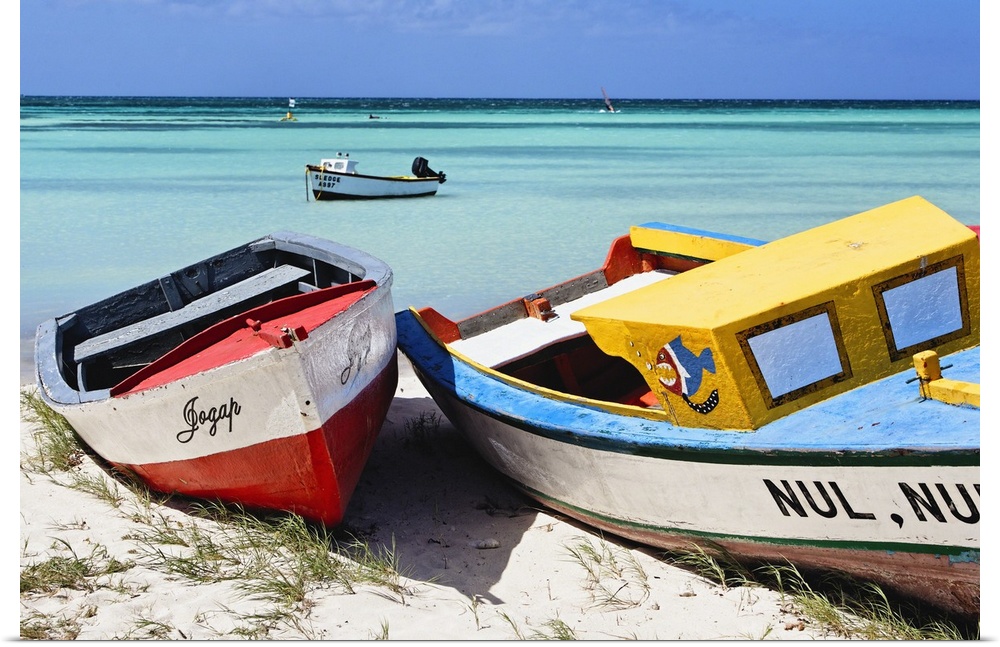 A photograph of colorful boats sitting on the shore of a tropical beach.