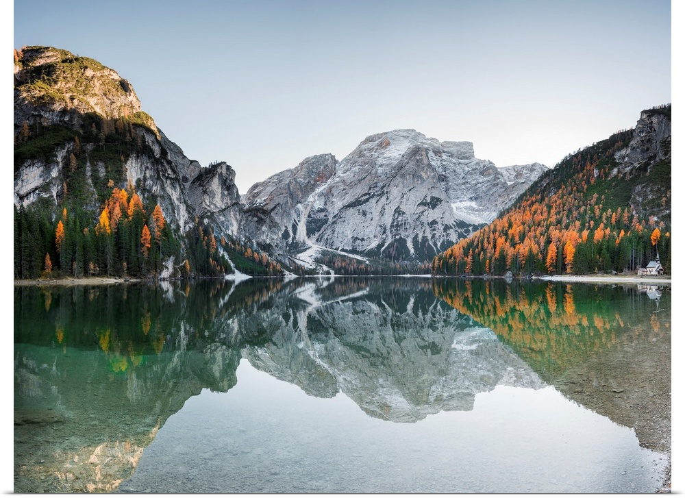Fine art photograph of the snowy mountains in Italy reflected in Braies lake.