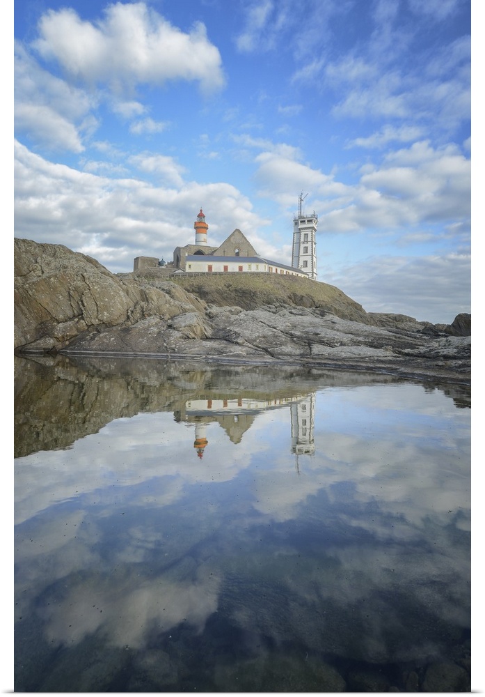 Saint Mathieu lighthouse on the coast reflected in the water below.