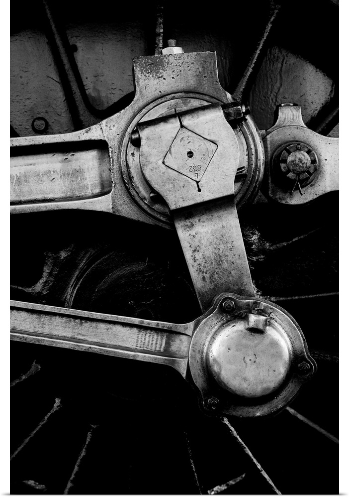 A close up in monochrome black and white of a steam engine main crank wheel.