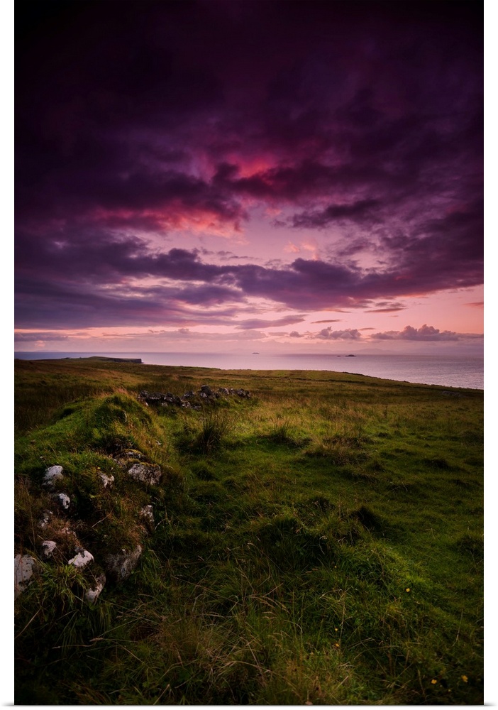 Fine art photo of a dramatic purple sky at sunset over a grassy meadow.
